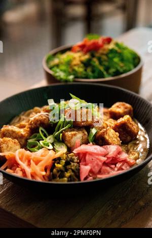 Tofu katsu curry with Japanese pickels and kale salad at Ivan Mazemen pop-up residency by ramen chef Ivan Orkin at Neighbourhood, Angel, London, UK Stock Photo