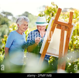 She appreciates his talent. a senior couple painting in the park. Stock Photo