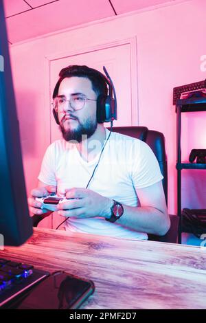 Professional video game player holding a joystick playing with a console. Stock Photo
