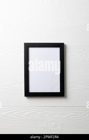 Vertical of black empty frame with copy space on white wall Stock Photo