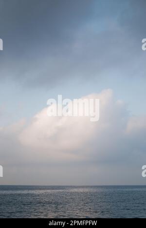 View of white clouds over calm ocean Stock Photo