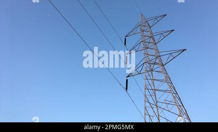 Electricity transmission towers with glowing wires Stock Photo