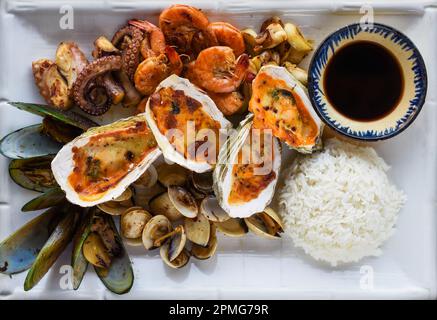Sauteed seafood on white plate close up isolated on black background top view Stock Photo