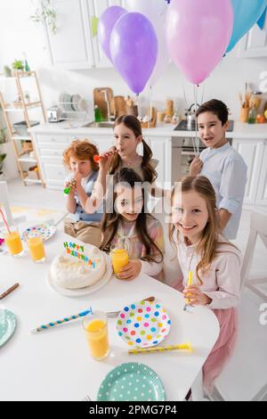 group of happy children blowing party horns during birthday celebration,stock image Stock Photo