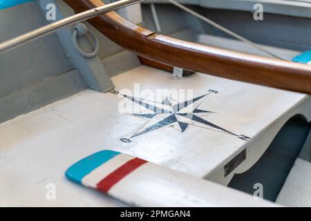 Antique compass painted on boat with white, red and blue antique oar Stock Photo