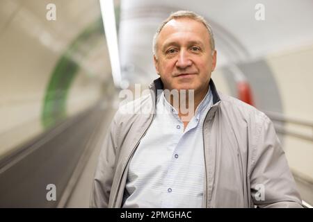 Middle aged man on moving walkway Stock Photo