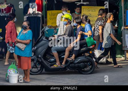 SAMUT PRAKAN, THAILAND, APR 07 2023, A man takes his family on a motorbike through the marketplace Stock Photo