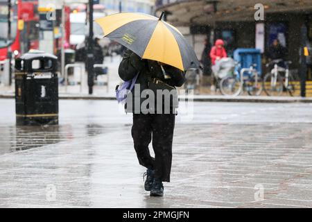 London, UK. 31st Mar, 2023. A man holds an umbrella to protect her from the rain in London. Dry and warm weather is expected for the next few days. Credit: SOPA Images Limited/Alamy Live News Stock Photo