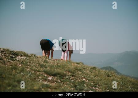 Yoga partners streching and making yoga poses at the top of the