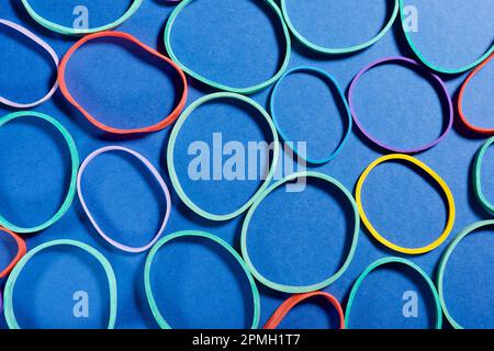 Close up of a group of elastic bands on a blue table Stock Photo
