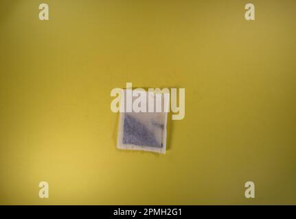 single square tea bags isolated on a yellow background Stock Photo
