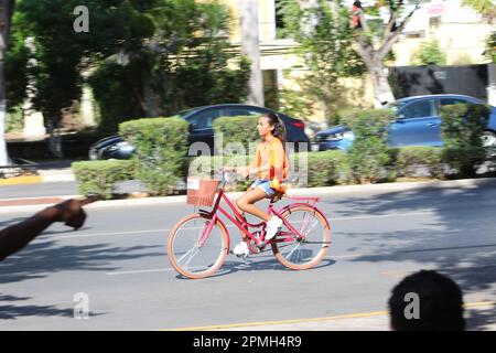 MERIDA, MEXICO - OCTOBER 30, 2016 Sunday cycling on the  Paseo de Montejo - girl in an orange top and white shoes Stock Photo