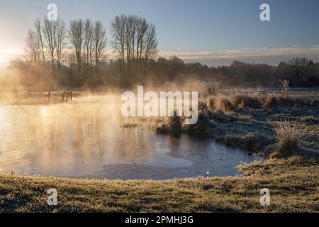 Frosty winter sunrise with mist on the River Test on Chilbolton Cow Common SSSI (Site of Special Scientific Interest), Wherwell, Hampshire, England Stock Photo