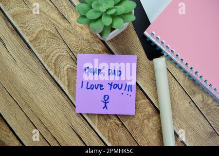 Concept of Dear Dad I Love You write on sticky notes isolated on Wooden Table. Stock Photo