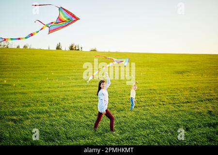 Happy children launch a kite in the field. Little boy and girl on summer vacation. Stock Photo