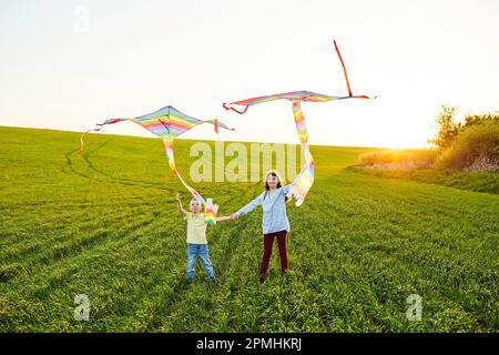 Happy children launch a kite in the field. Little boy and girl on summer vacation. Stock Photo