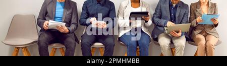 Several people using tablet and laptop computers while waiting for business meeting Stock Photo
