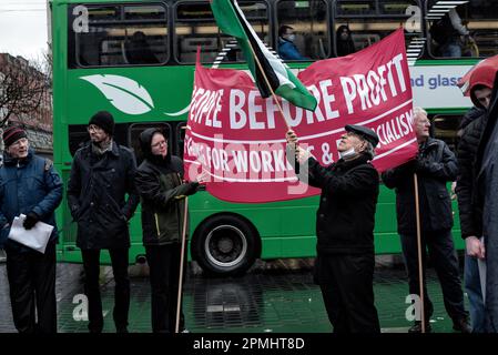 Protesters wave flags and hold a banner in opposition to Biden's visit to Ireland. Protesters gathered to oppose Biden's visit to Ireland in Dublin City centre where many organisations and groups attended in support, including People Before Profit, the Ireland-Palestine Solidarity Campaign, the Irish Anti-War Movement, the Communist Party of Ireland, and the Connolly Youth Movement, among others. The protest included a few speakers, one of them was Richard Boyd Barrett from People Before Profit. (Photo by Natalia Campos/SOPA Images/Sipa USA) Stock Photo
