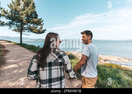 Young couple taking a walk near the ocean in Galicia, Spain Stock Photo