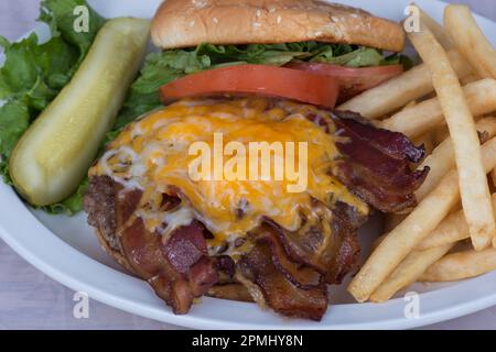 Cowboy Bacon Cheeseburger with a Side of Fries and a dill Pickle Stock Photo