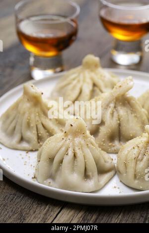 homemade khinkali dumplings with chacha (Georgian pomace brandy ), Georgian cuisine Stock Photo