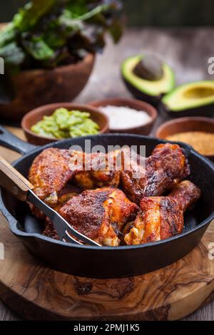 Grilled chicken legs and wings with guacamole, frish salad and spicies Stock Photo