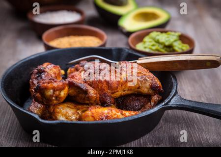 Grilled chicken legs and wings with guacamole, frish salad and spicies Stock Photo