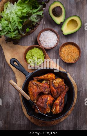 Grilled chicken legs and wings with guacamole, frish salad and spicies Stock Photo