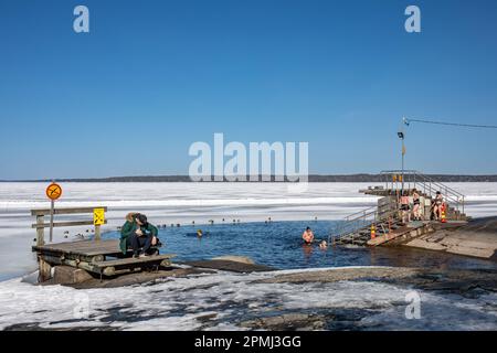 Ice swimming at Rauhaniemen kansankylpylä or Rauhaniemi Folk Spa on a sunny spring day in Tampere, Finland Stock Photo