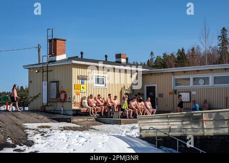 People cooling off after sauna on a sunny spring day at Rauhaniemi Folk Spa or Rauhanniemen kansankylpylä in Tampere, Finland Stock Photo