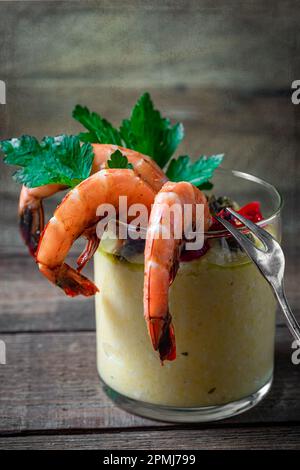 Steamed shrimp in small glass with polenta. Above shot, close up. Stock Photo