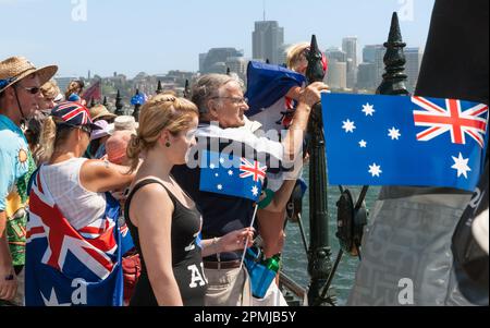 Sydney Australia - January 25 2011; Crowd of people on walkway edge to harbour hold flags celebrating Australia Day Stock Photo