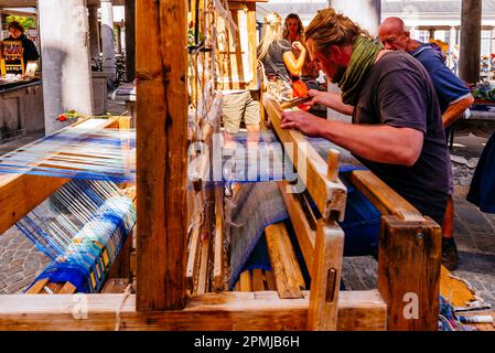 Craftsman manufactures cloth on an old loom. Craft market in the afternoon. Vismarkt, Fish Market. Architect Jean-Robert Calloigne designed a Classica Stock Photo