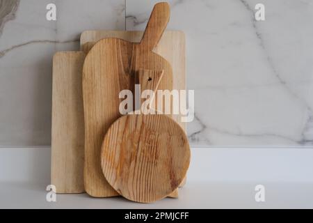 Wooden chopping boards on kitchen countertops. Set of wood cutting boards in different sizes. Stock Photo