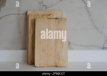 Wooden chopping boards on kitchen countertops. Set of wood cutting boards in different sizes. Stock Photo