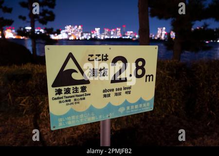 Tokyo, Japan. 9th Feb, 2023. A Tsunami elevation warning sign. Disaster preparedness, earthquakes.Odaiba Marine Park (ãŠå°å ´æµ·æµœå…¬åœ') is a public park in Tokyo, Japan. It is located on the artificial island of Odaiba in Tokyo Bay. The park has a beach, a promenade, and a variety of attractions, including a replica of the Statue of Liberty.The Japanese economy is the third largest in the world, after the United States and China. It is a highly developed market economy with a strong manufacturing sector. The Japanese economy is also heavily reliant on exports, and it has been strug Stock Photo