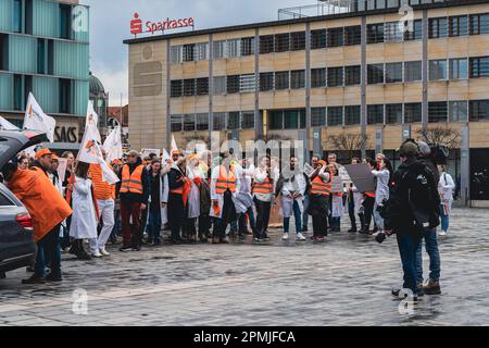 Group of doctors and caregivers align in front of a TV crew with protesting signs, during a warning strike, Kaiserslautern, Germany Stock Photo