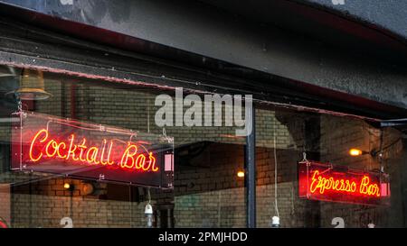 London, United Kingdom - February 02, 2019: Bright yellow cocktail and espresso bar neon sign on restaurant window, closeup detail Stock Photo