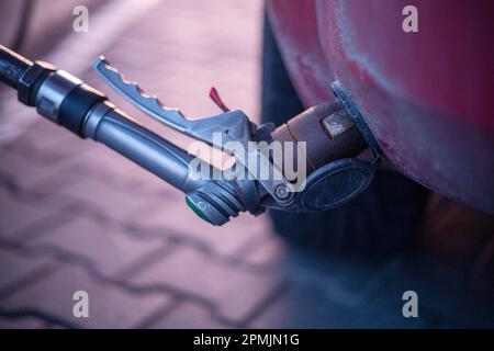 insert the pump into the valve of the gas filling machine at the gas station Stock Photo