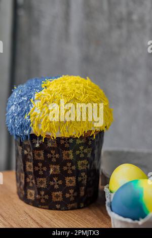 Easter cake is decorated with yellow-blue sprinkles on a gray background. place for text. patriotic paska in the color of the flag of Ukraine. Easter Stock Photo