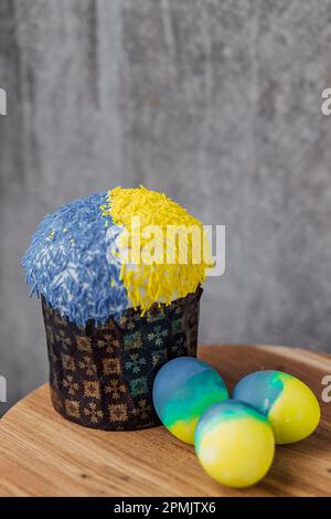 Easter cake is decorated with yellow-blue sprinkles on a gray background. place for text. patriotic paska in the color of the flag of Ukraine. Easter Stock Photo