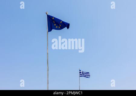 European Union EU and Greece flags is flying in air on blue sky background. Banner, place for text. High quality photo Stock Photo