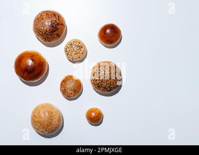 Top view of four freshly baked small breads with sesame, nigella seeds, poppy seeds, chia seeds Stock Photo