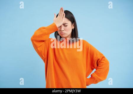 Now thats epic. Studio shot of a young woman with air being blown in her  face against a blue background Stock Photo - Alamy