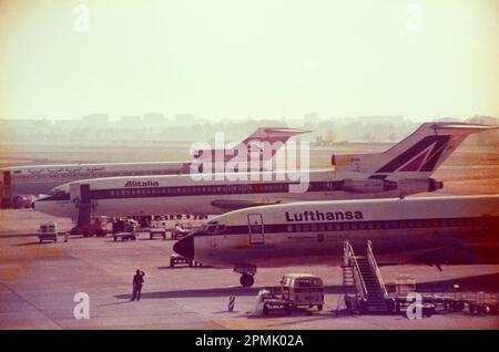 Three Boeing 727 -200 of three different airlines: Lufthansa, former Alitalia and Libyan arab airline parked at Linate airport (Milan) in mid eighties Stock Photo