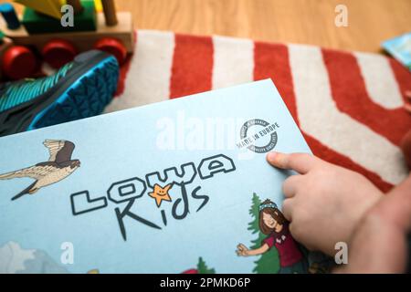 Frankfurt, Germany - Mar 12, 2023: One kid pointing to the cardboard pacakge of Lowa Kids insulated and waterproof shoes. Perfect for winter adventures Stock Photo