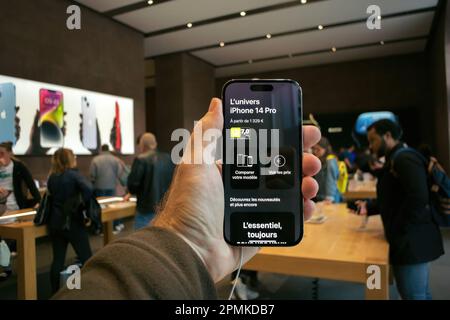 Paris, France - Sep 22, 2022: Hand holding Apple iPhone 14 Pro Max with Apple Store crowd in background background. Apple 2023 2022 flagship iPhone. Stock Photo