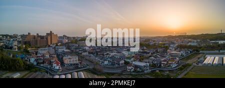 Aerial panoramic view of apartments and houses in small town at sunset Stock Photo