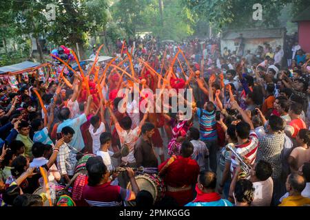 Bangladesh, 13/04/2023, As the month of Chaitra, the last in the Bangla year draws to an end, the Hindu community comes together in a festival dedicated to the worship of Lord Shiva and Parvati. The program is locally known as “Lal Kach” (red glass). The central idea behind this program is for a group of soldiers led by Shiva to appear on earth with a mission: ward off the forces of evil. These soldiers, glowing in the divine light of Shiva, march toward nearby temples. It is all part of a very long tradition going back hundreds of years. The Hindus, especially the young, paint themselves in r Stock Photo