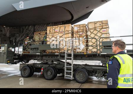 Royal Australian Air Force Squadron Leader Stephen Grimmer, assigned to the Persistent Maritime Unmanned Aircraft Systems Program Office (PMA-262) Triton – Cooperative Program out of Naval Air Station Patuxent River, Maryland, watches Forward Operating Base equipment being loaded onto a C-17 Globemaster III by 436th Aerial Port Squadron personnel at Dover Air Force Base, Delaware, Feb. 1, 2023. The FOB equipment and a Mobile Remote Quick Look trailer was flown to Andersen AFB, Guam, by a 3rd Airlift Squadron aircrew. (U.S. Air Force photo by Roland Balik) Stock Photo